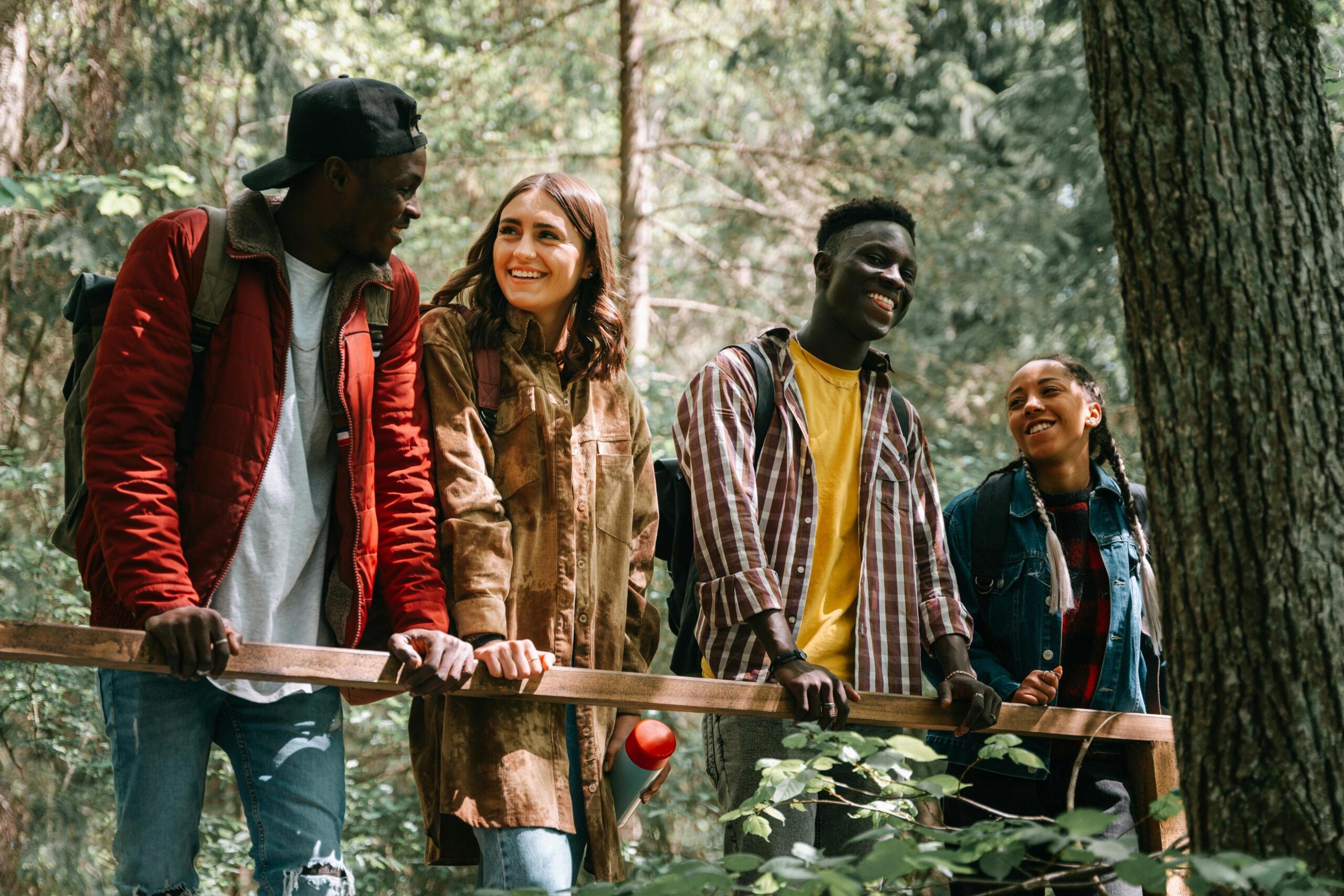 a smiling group of friends hiking in a forest