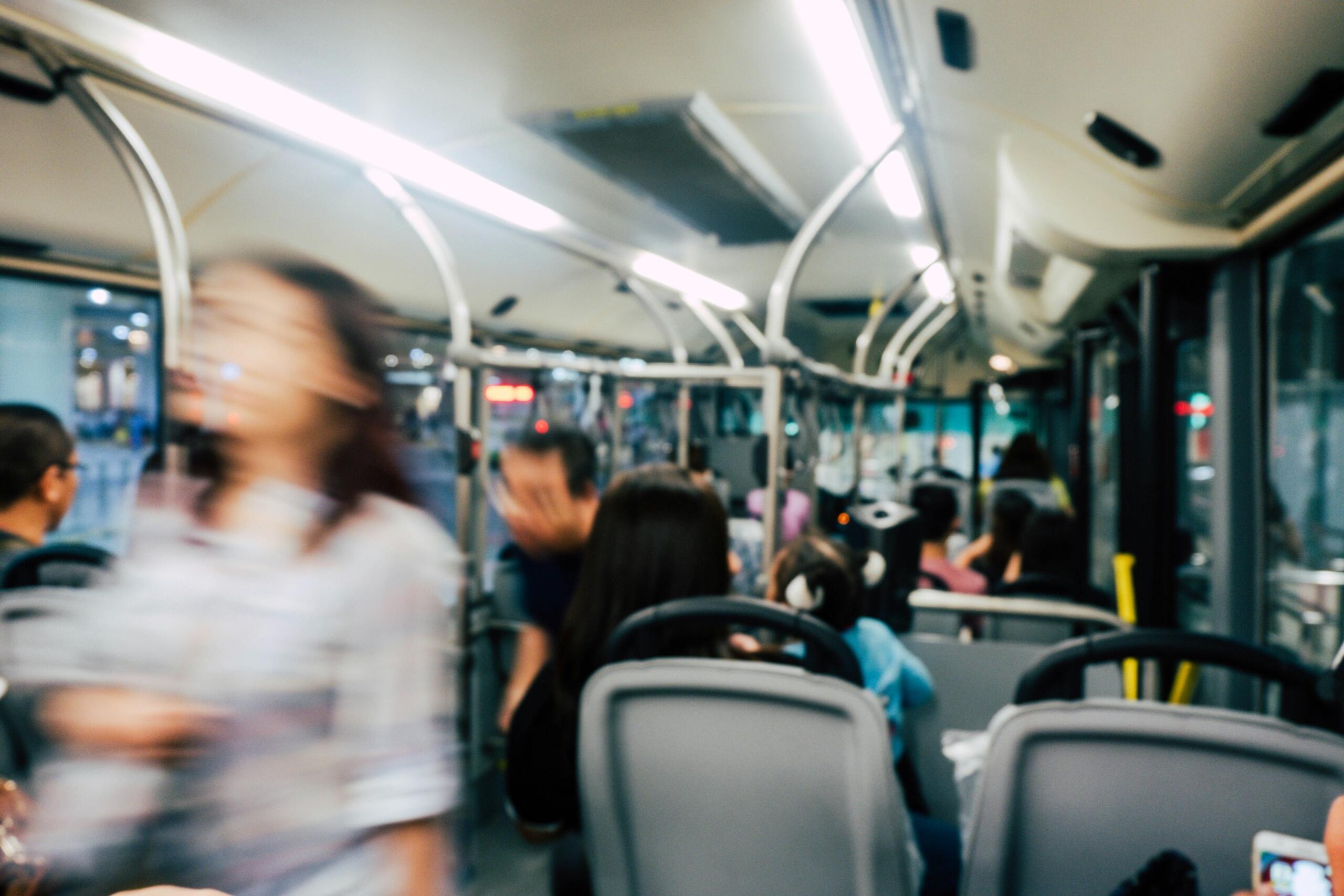 A blurred image of a bus full of people.