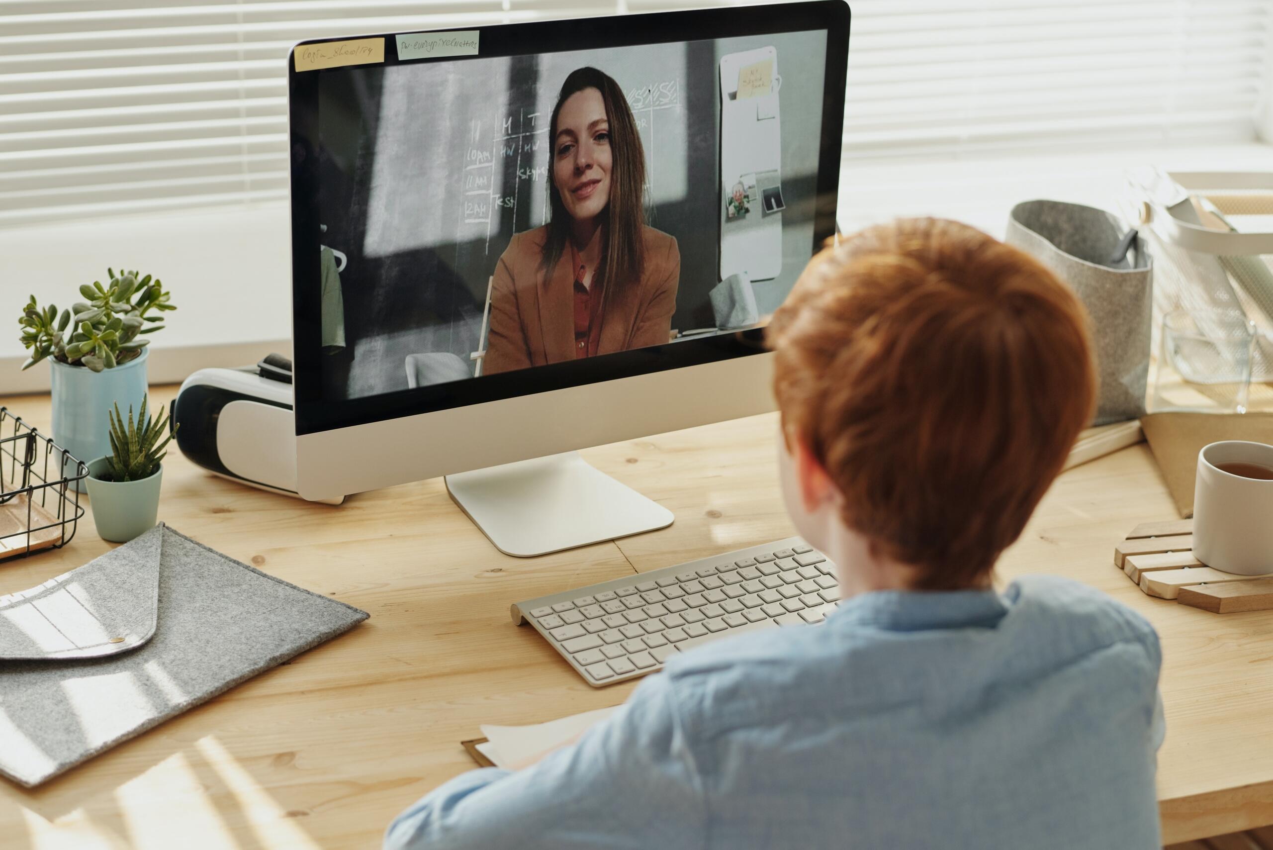 boy and teacher connecting online on laptop