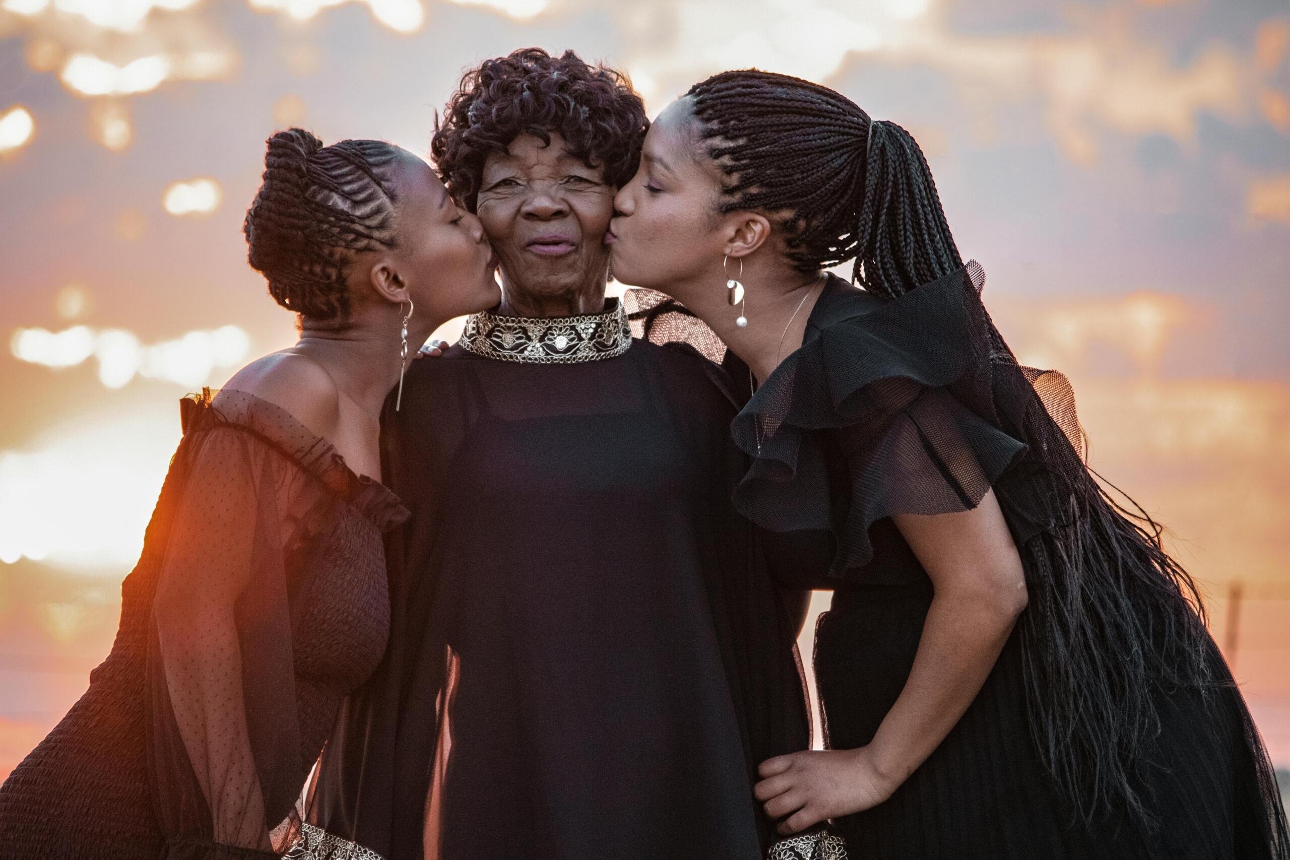 A group of well-dressed women honour the elder woman in the group.