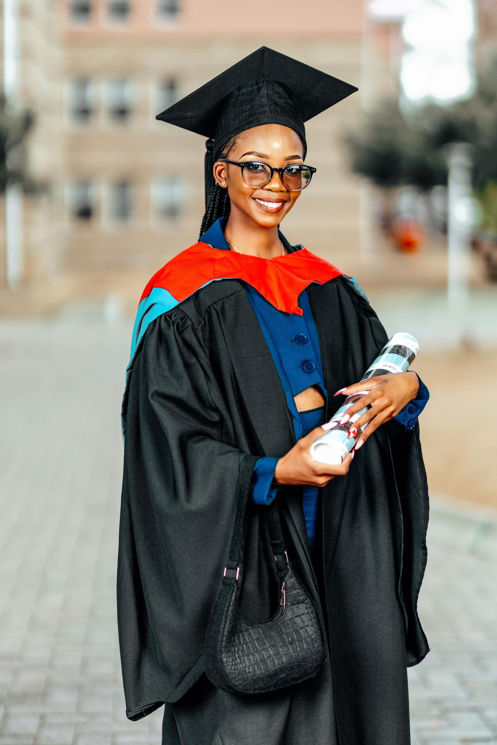 An image u university graduate holding a scroll.