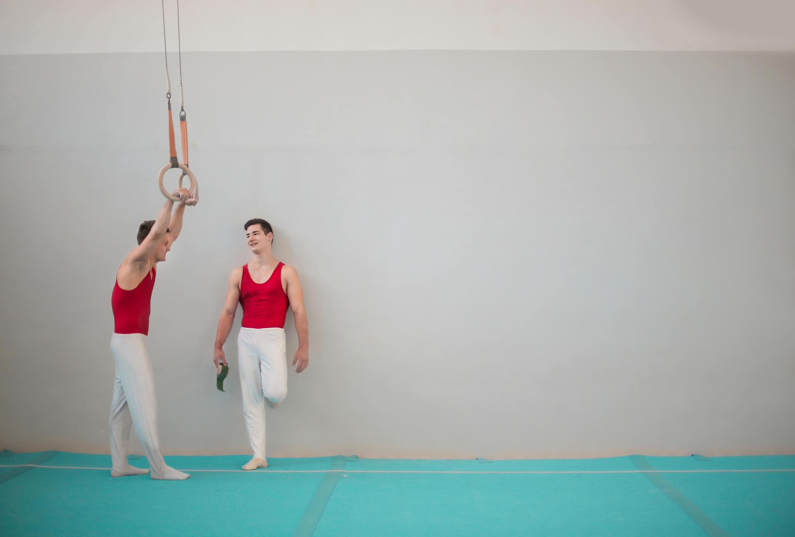 Two elite gymnasts take a break in the gym.