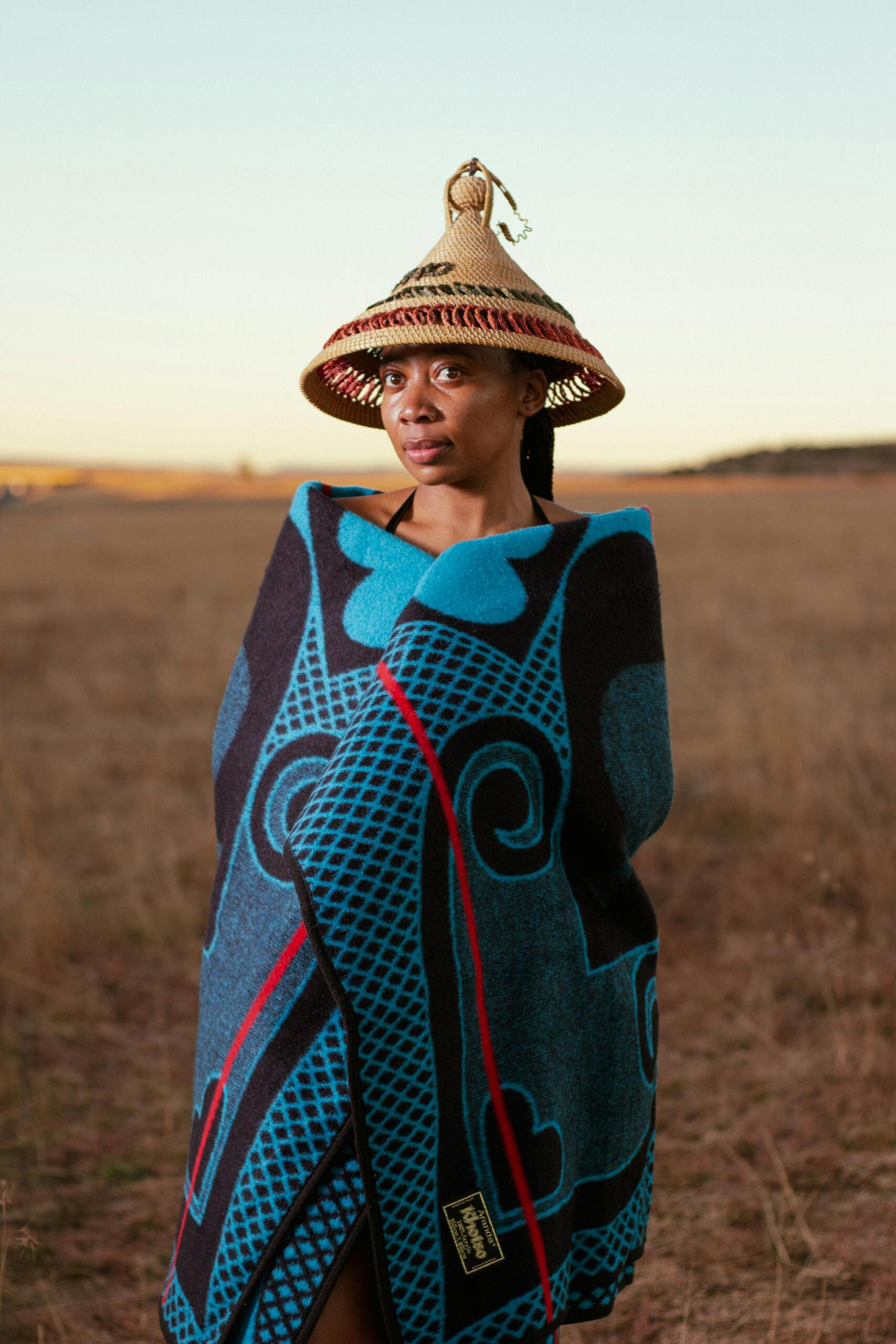 An image of a Sotho woman with a traditional hat and blanket.