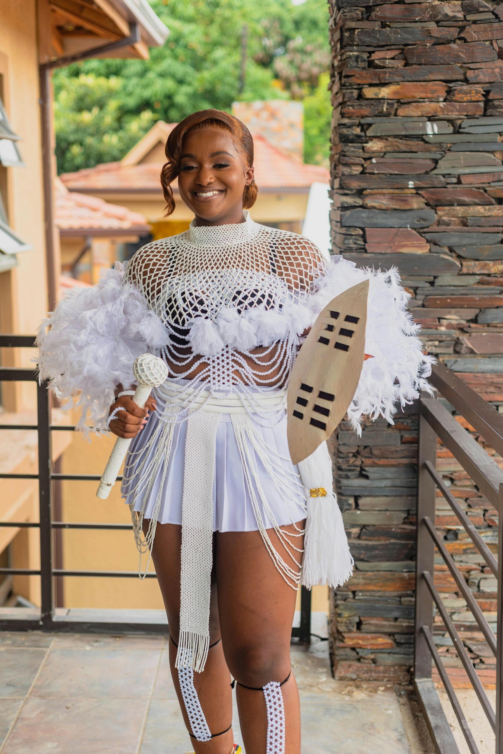 woman wearing zulu traditional outfit and holding a shield made of animal hide