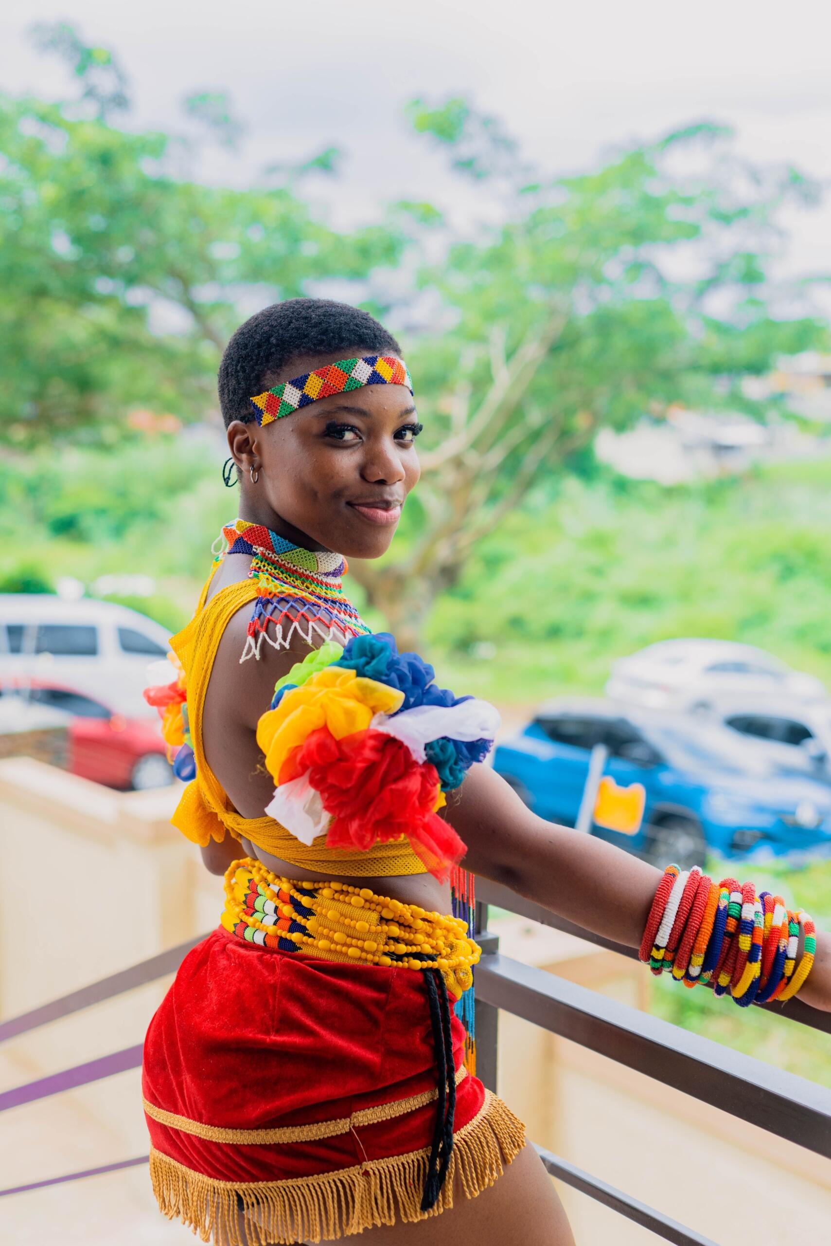 woman wearing a colourful zulu traditional outfit and beadedvheadband