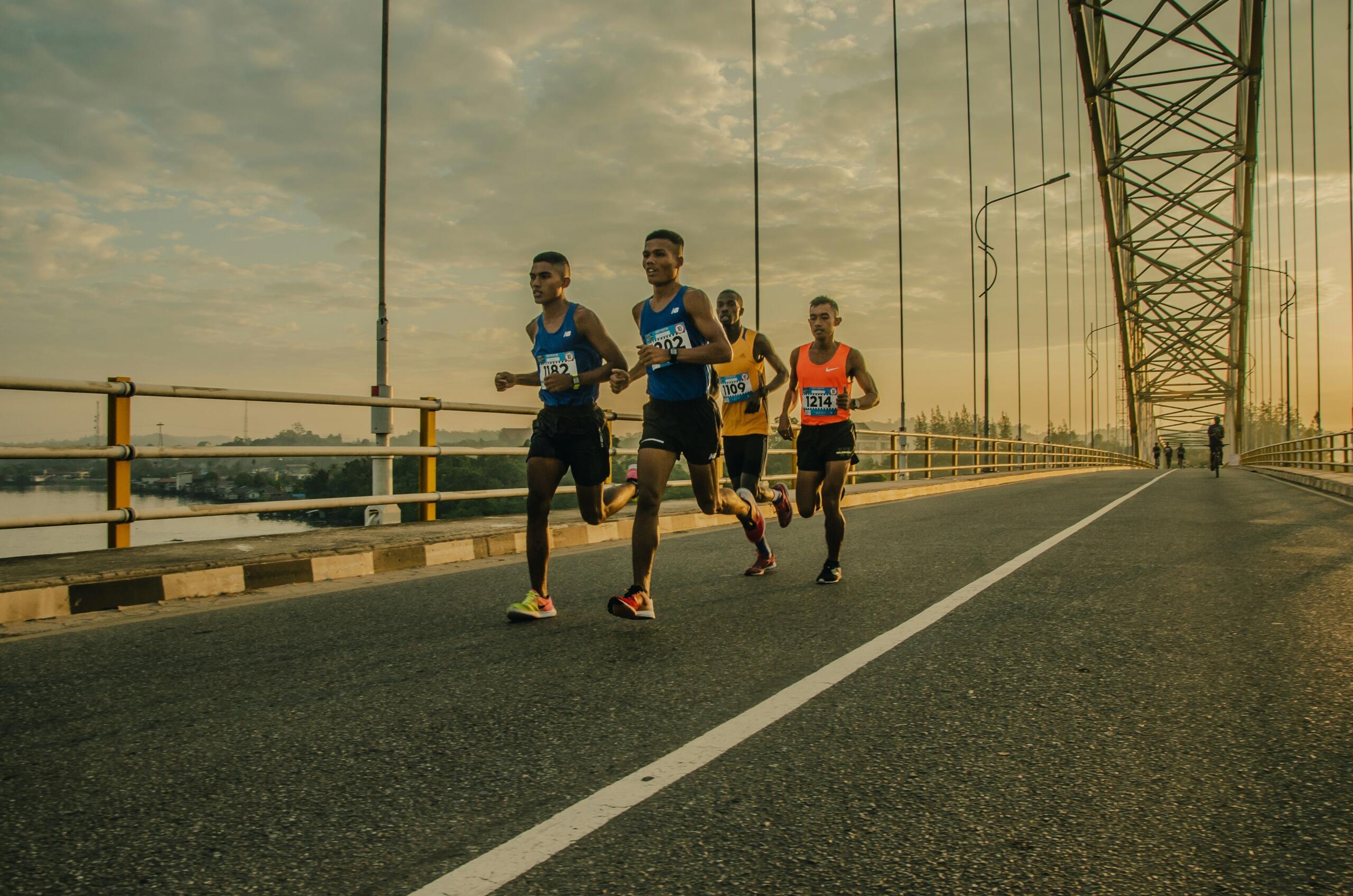 A group of road runners train together in the soft evening light.
