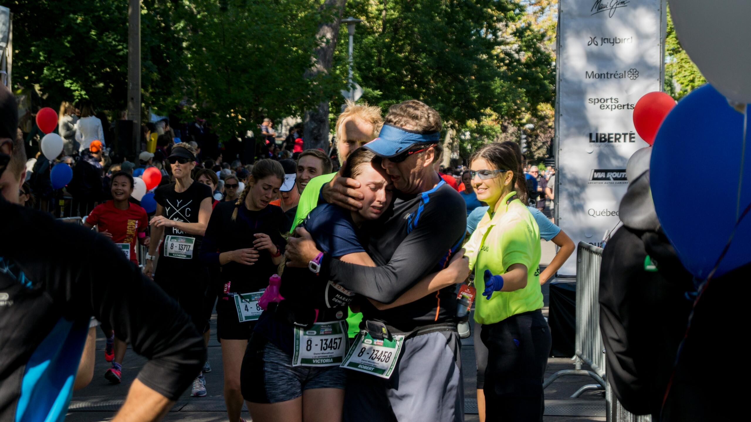 An image of two runners in an embrace where one is offering solidarity and support.
