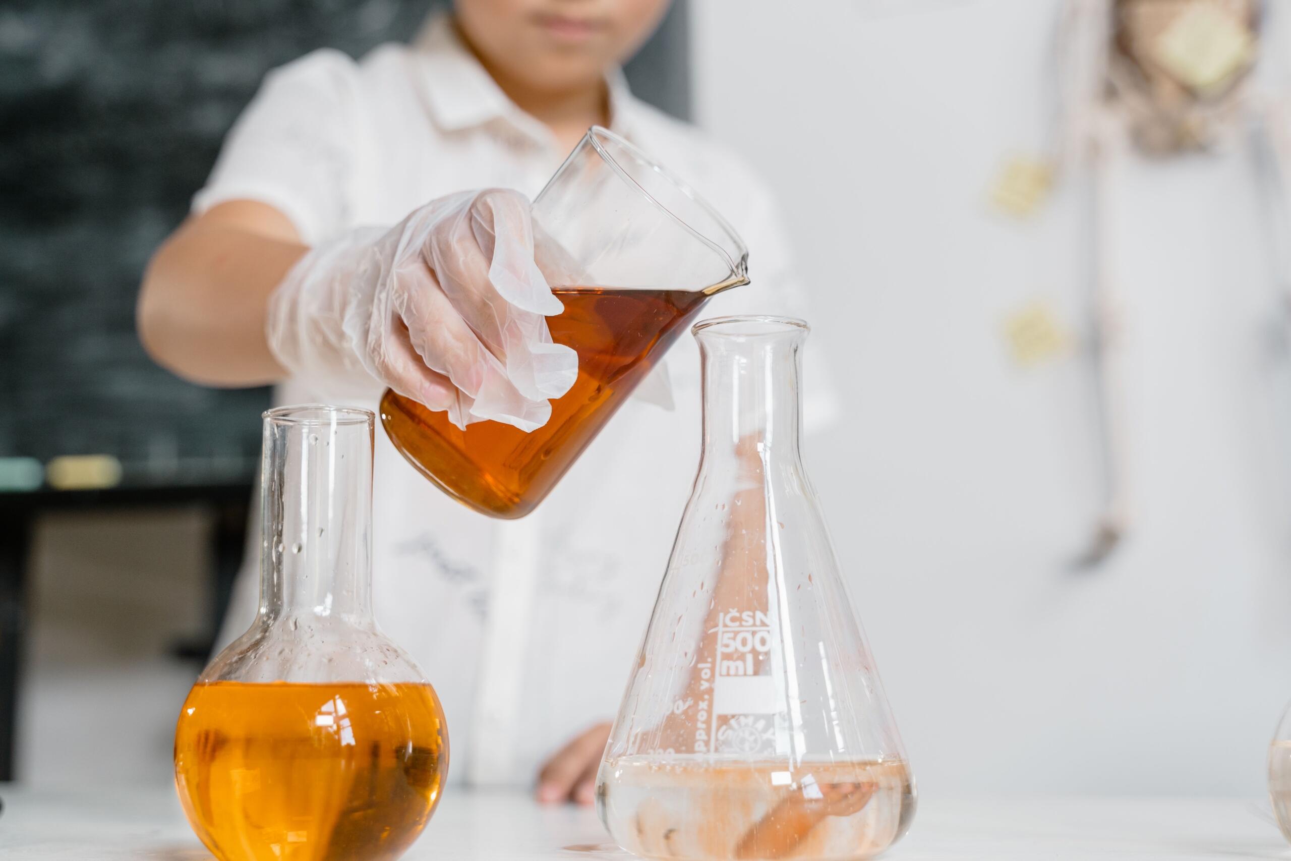 child mixing liquids in beakers
