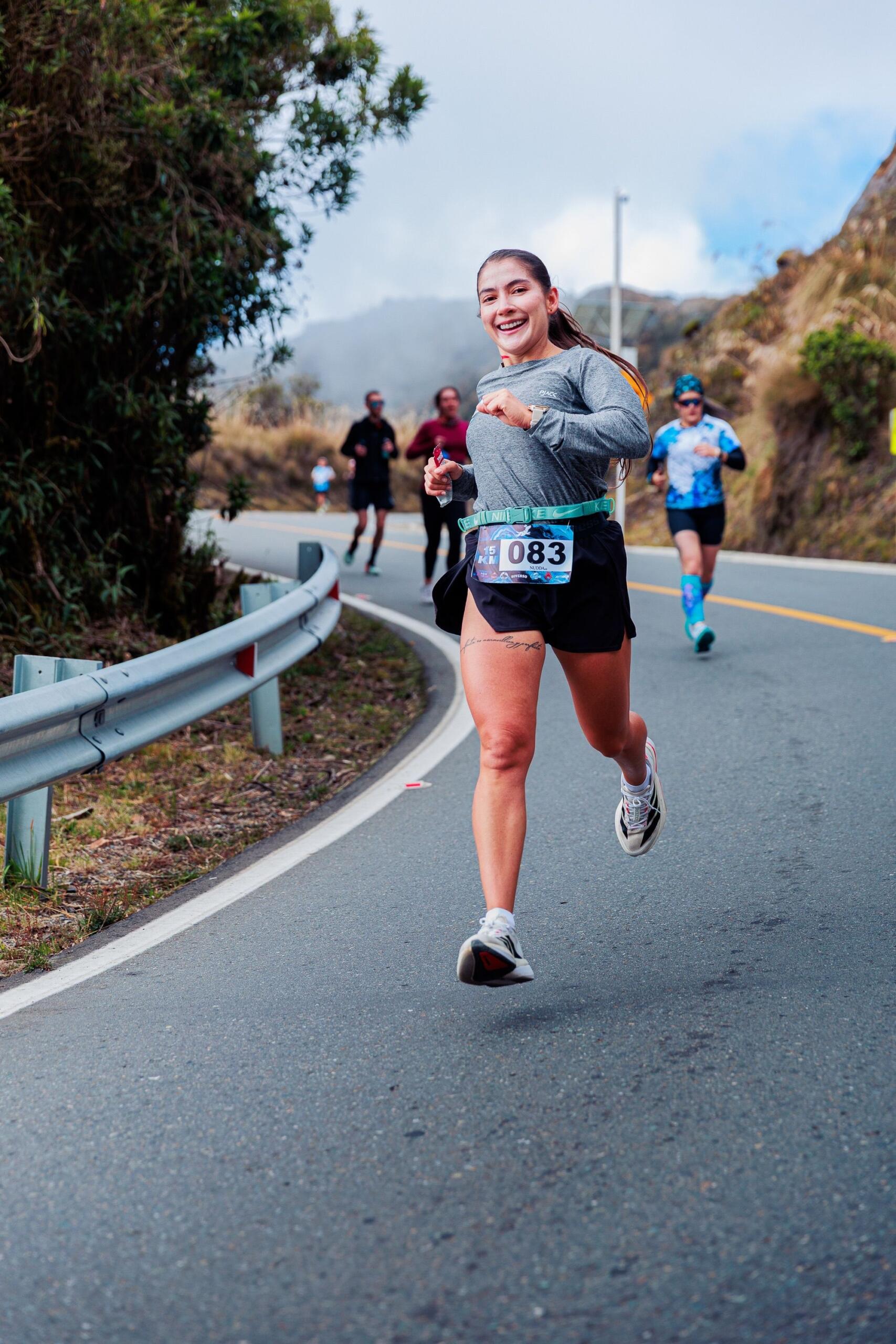 An image of a woman running downhill during a marathon