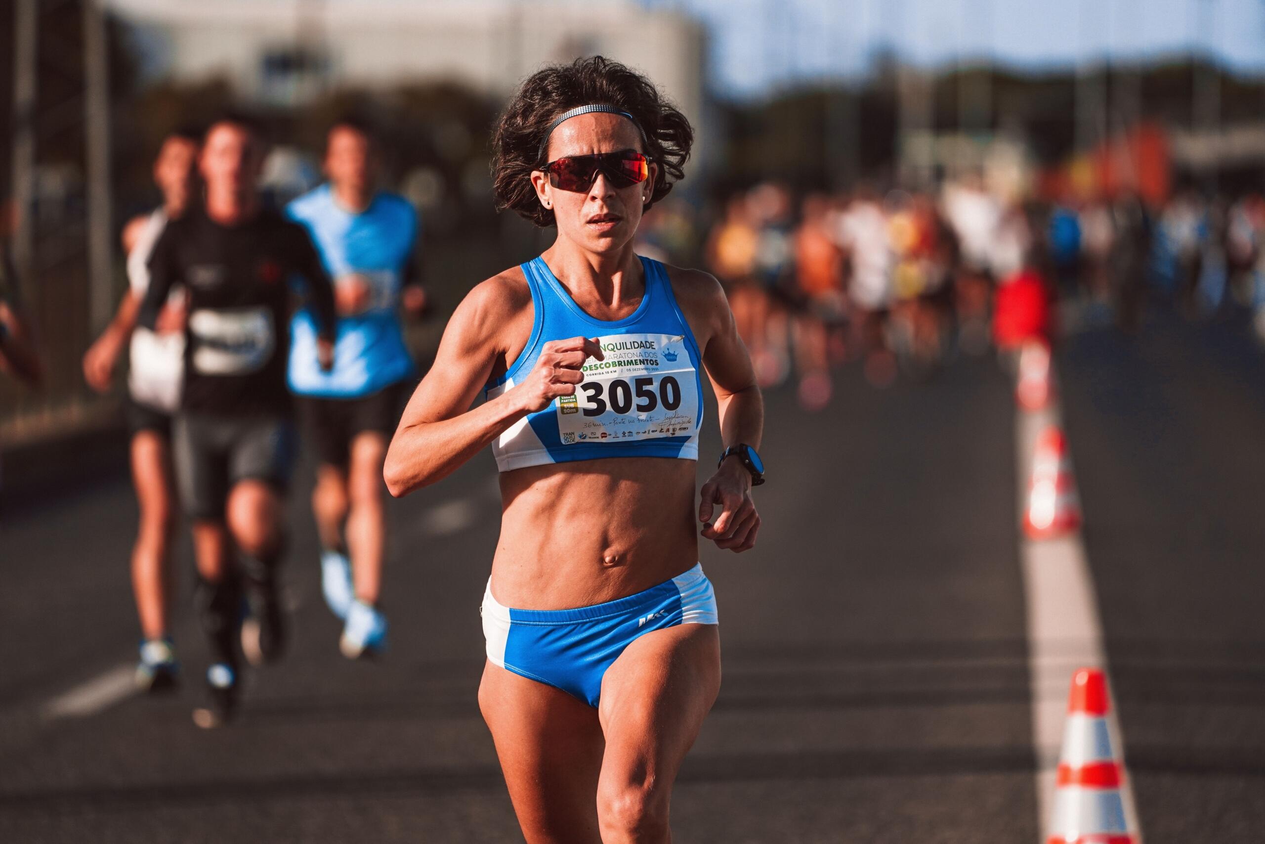 An image of a woman in full stride during a road race.