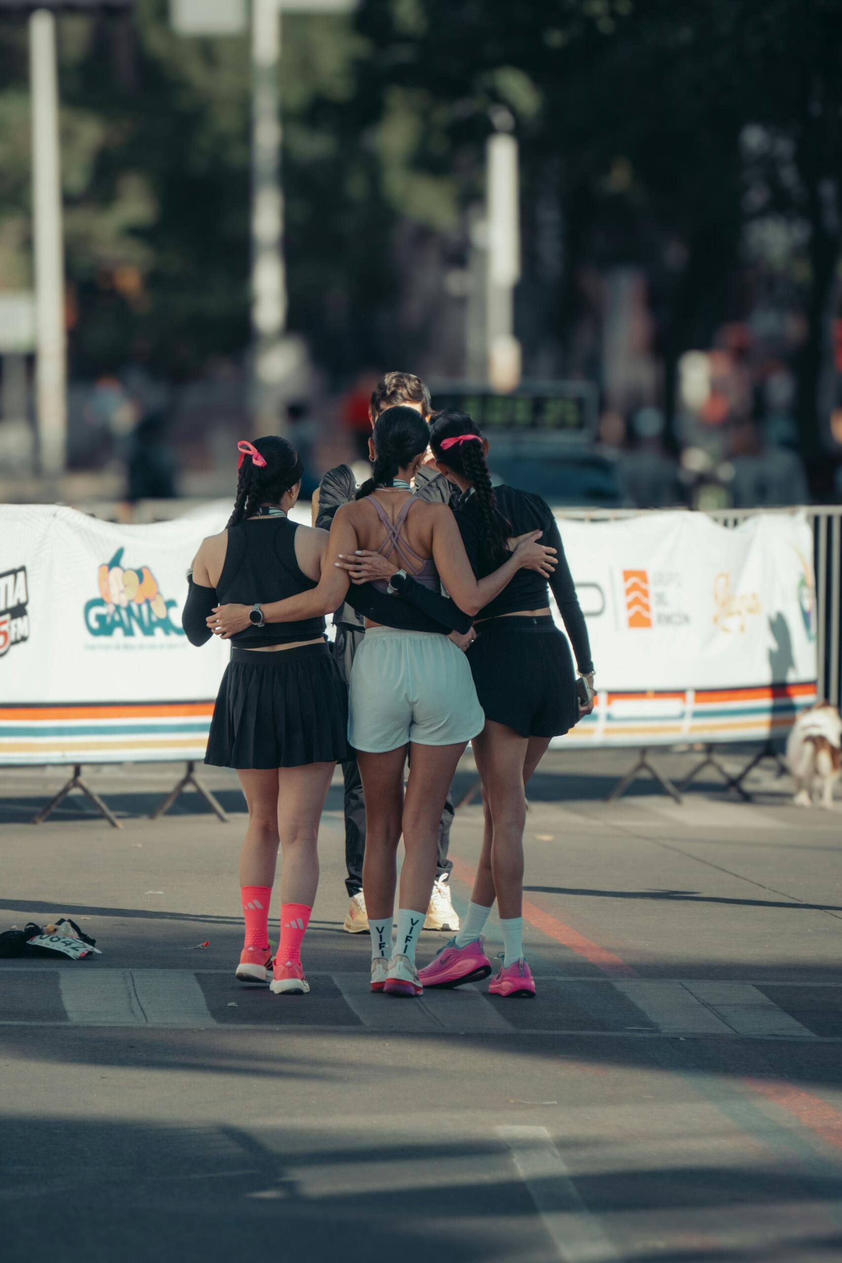 A group of women embrace in sporting solidarity.