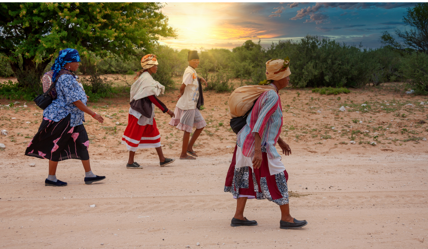 four San women wearing traditional clothing and headdresses