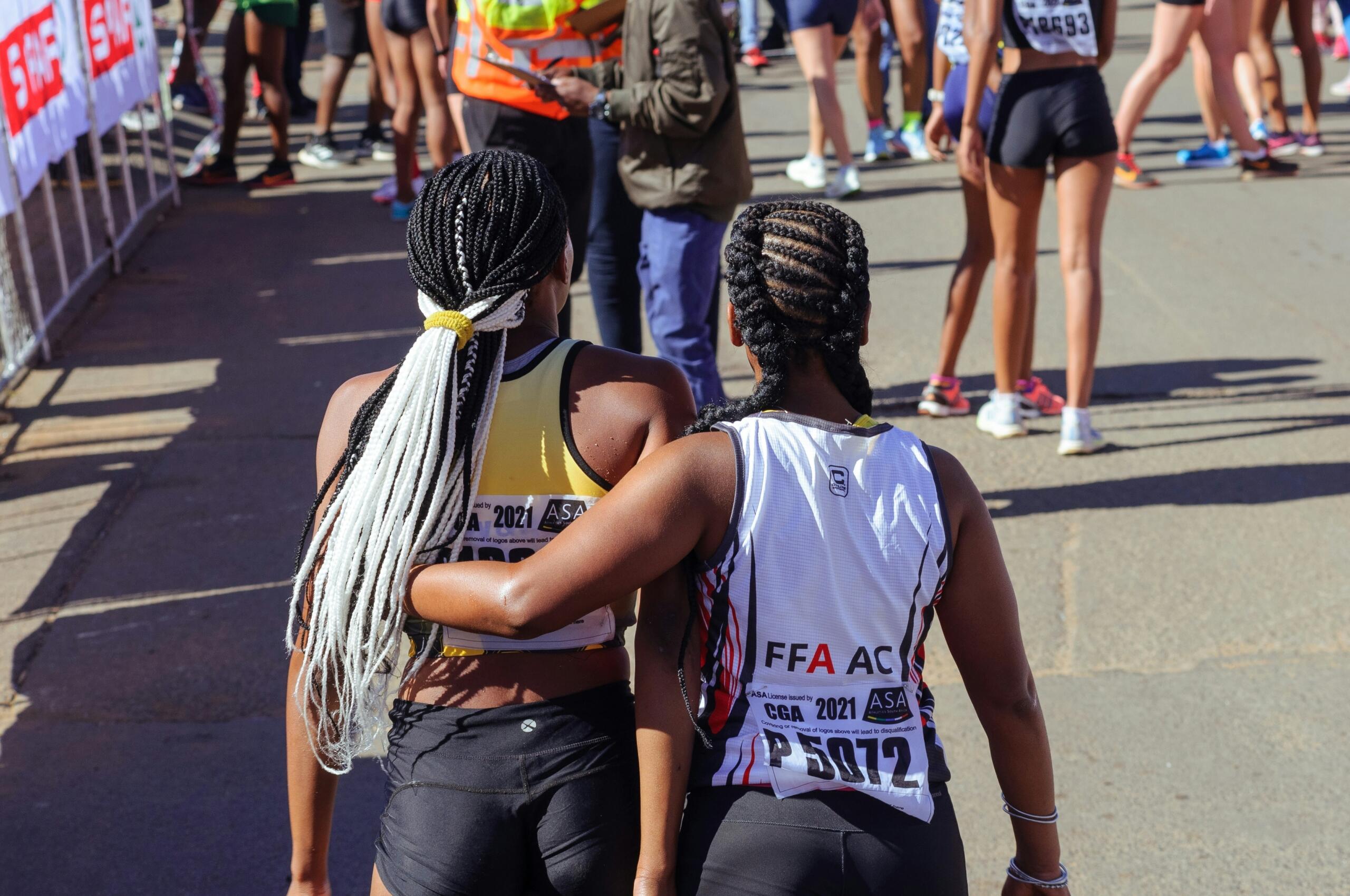 Two women support each other during a marathon.