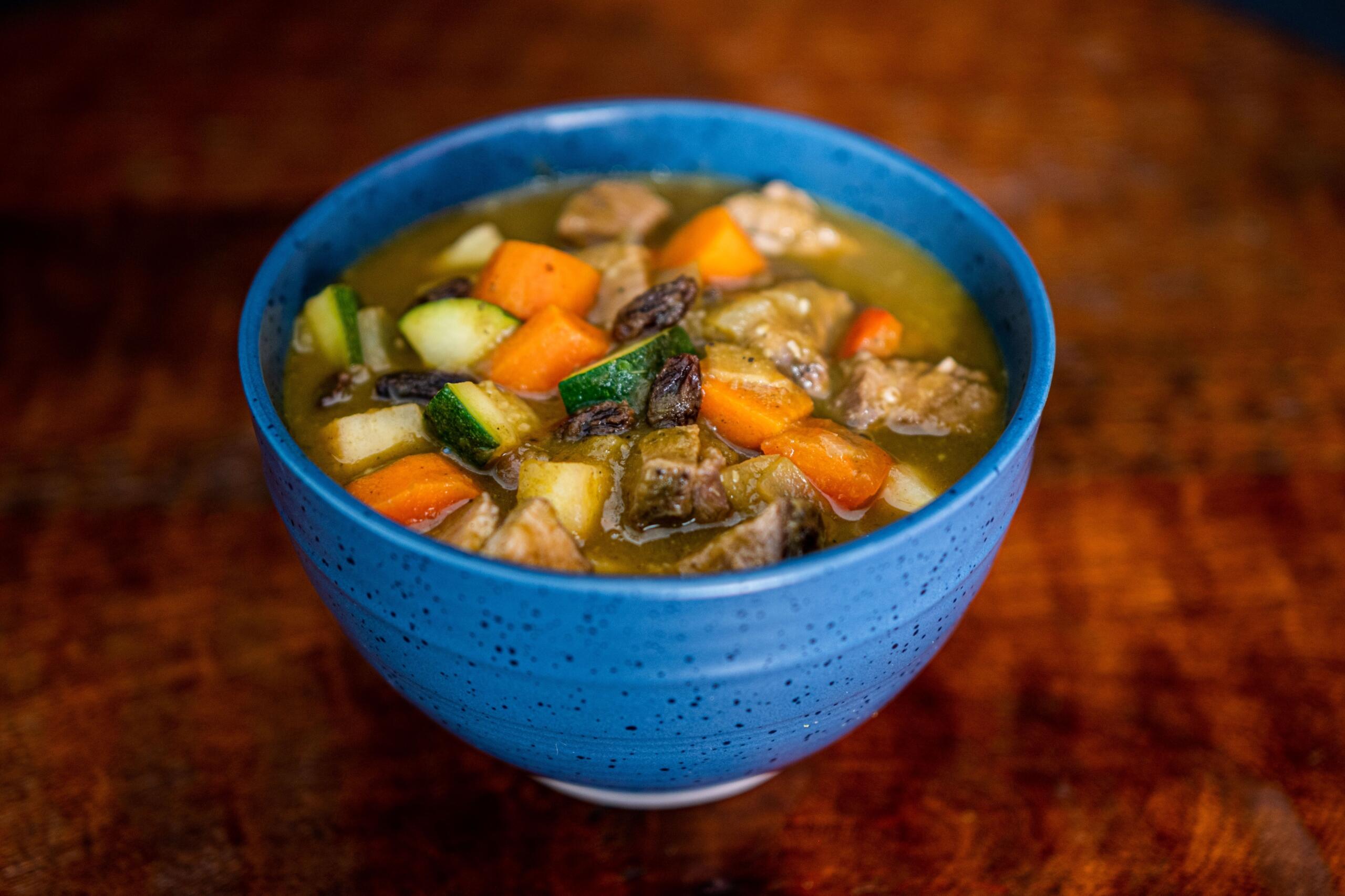 An image of a blue ceramic bowl filled with hearty stew.