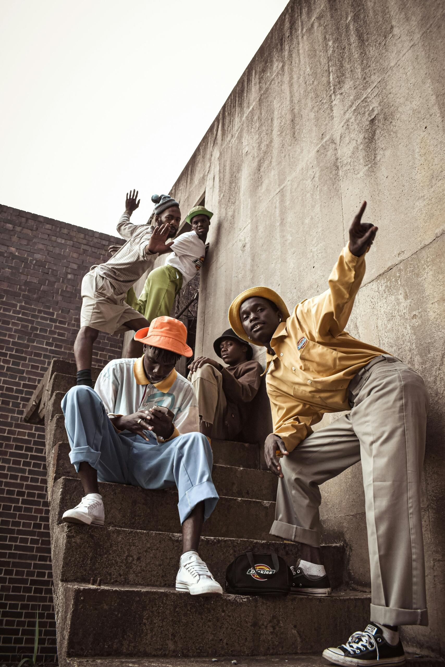 Five young South African men posing on a staircase in an urban neighbourhood.