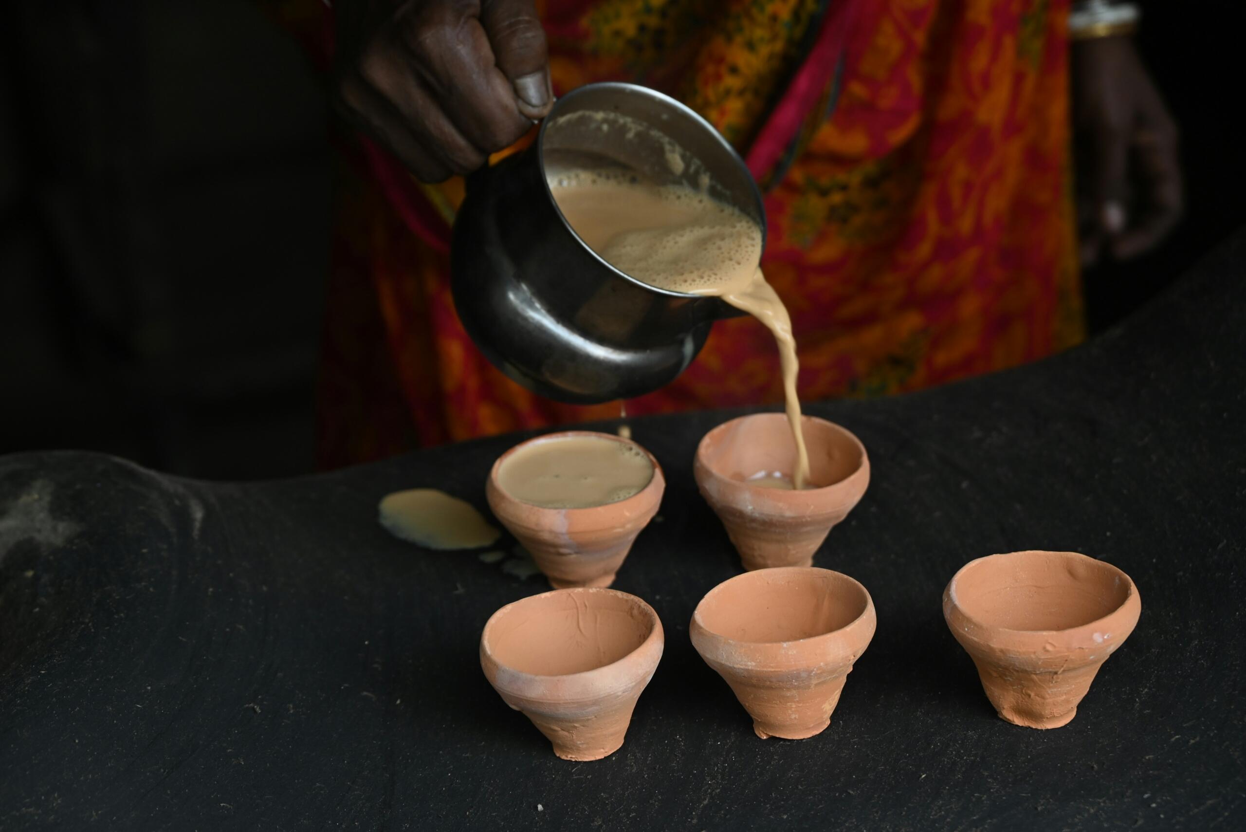 Tea being poured in clay cups