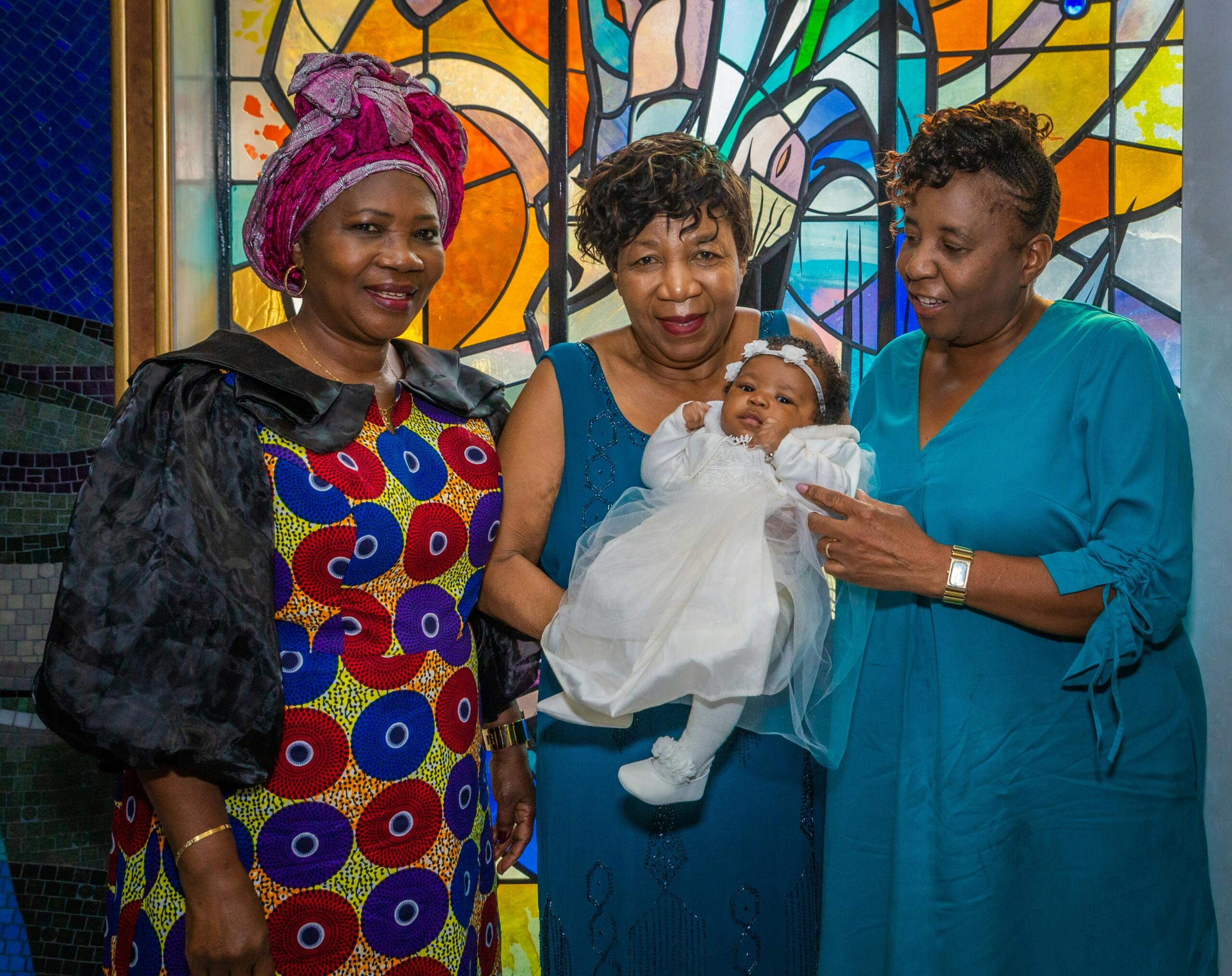 An image of three women and a baby at a naming or christening ceremony.