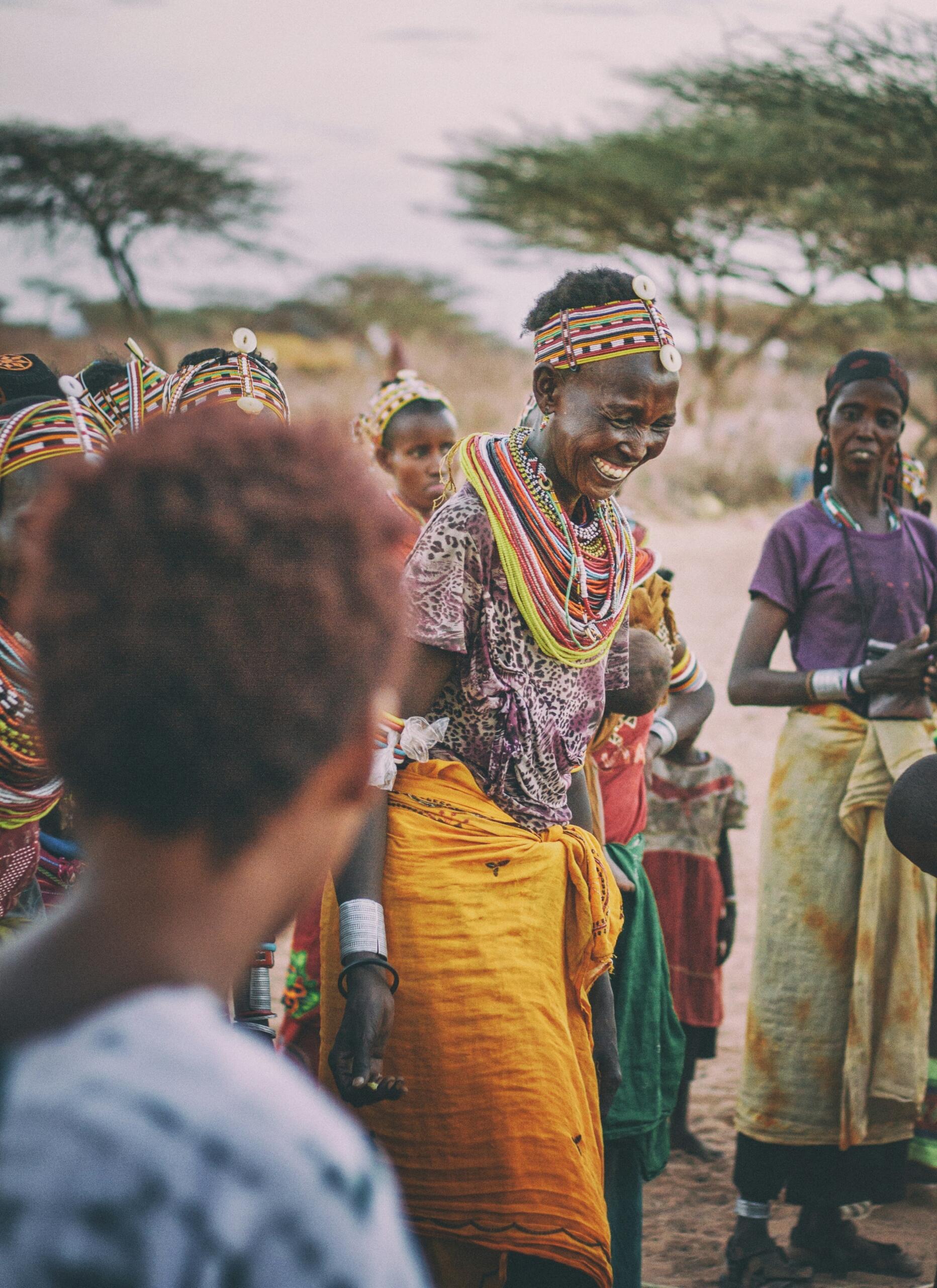 People in colourful traditional clothing and beadwork taking part in a cultural celebration in East Africa.