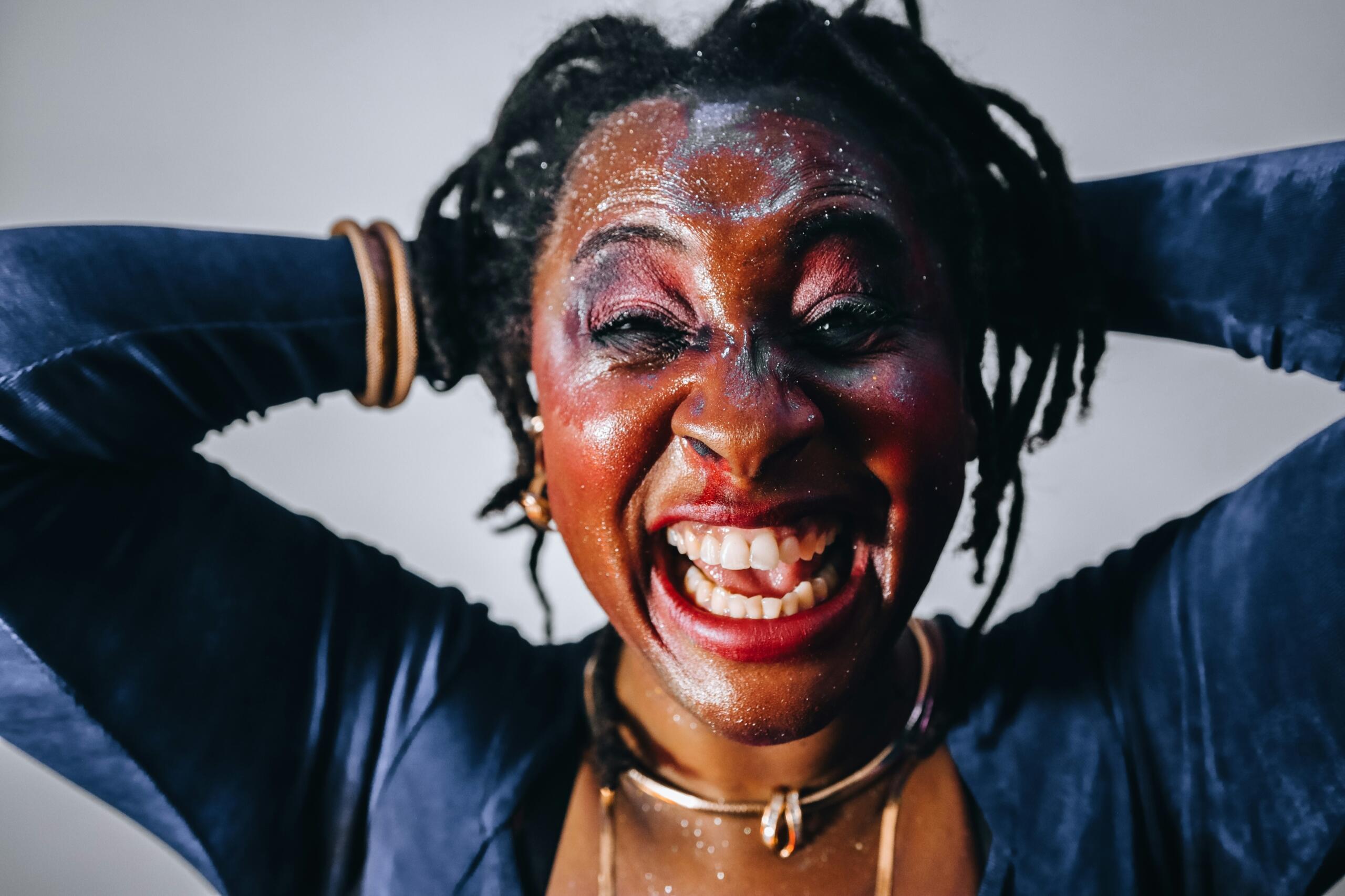 A portrait of a woman showing emotions of joy and celebration.