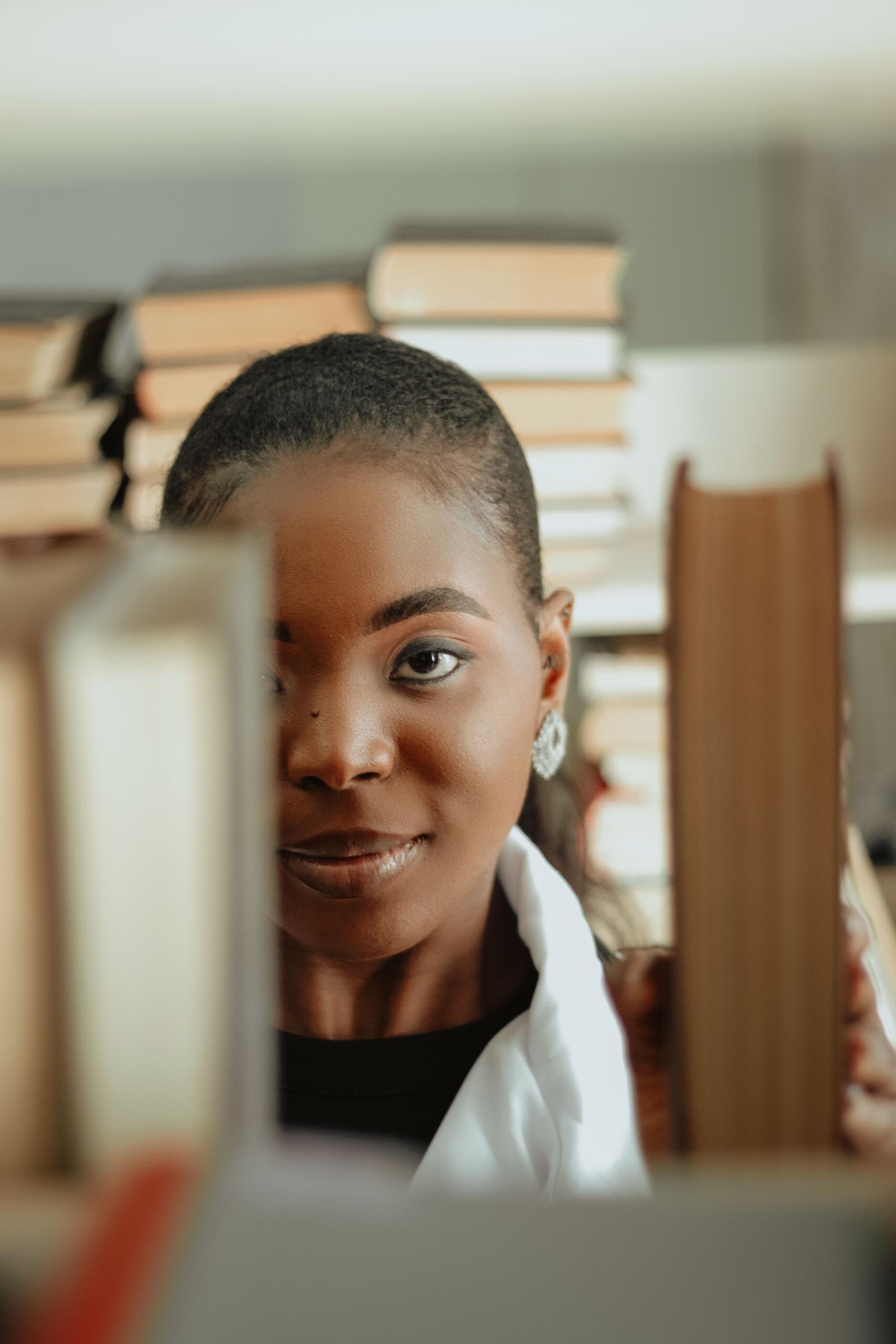 image of a woman's face taken through the shelves of a library