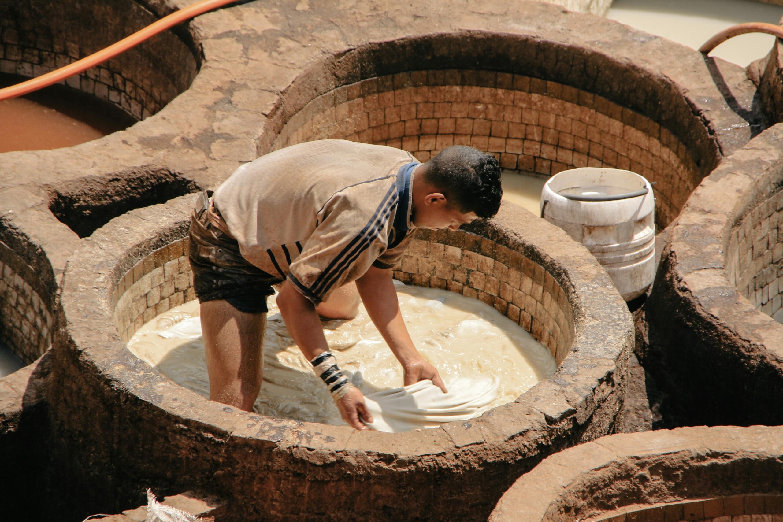 A man working outside to ferment and preserve food.