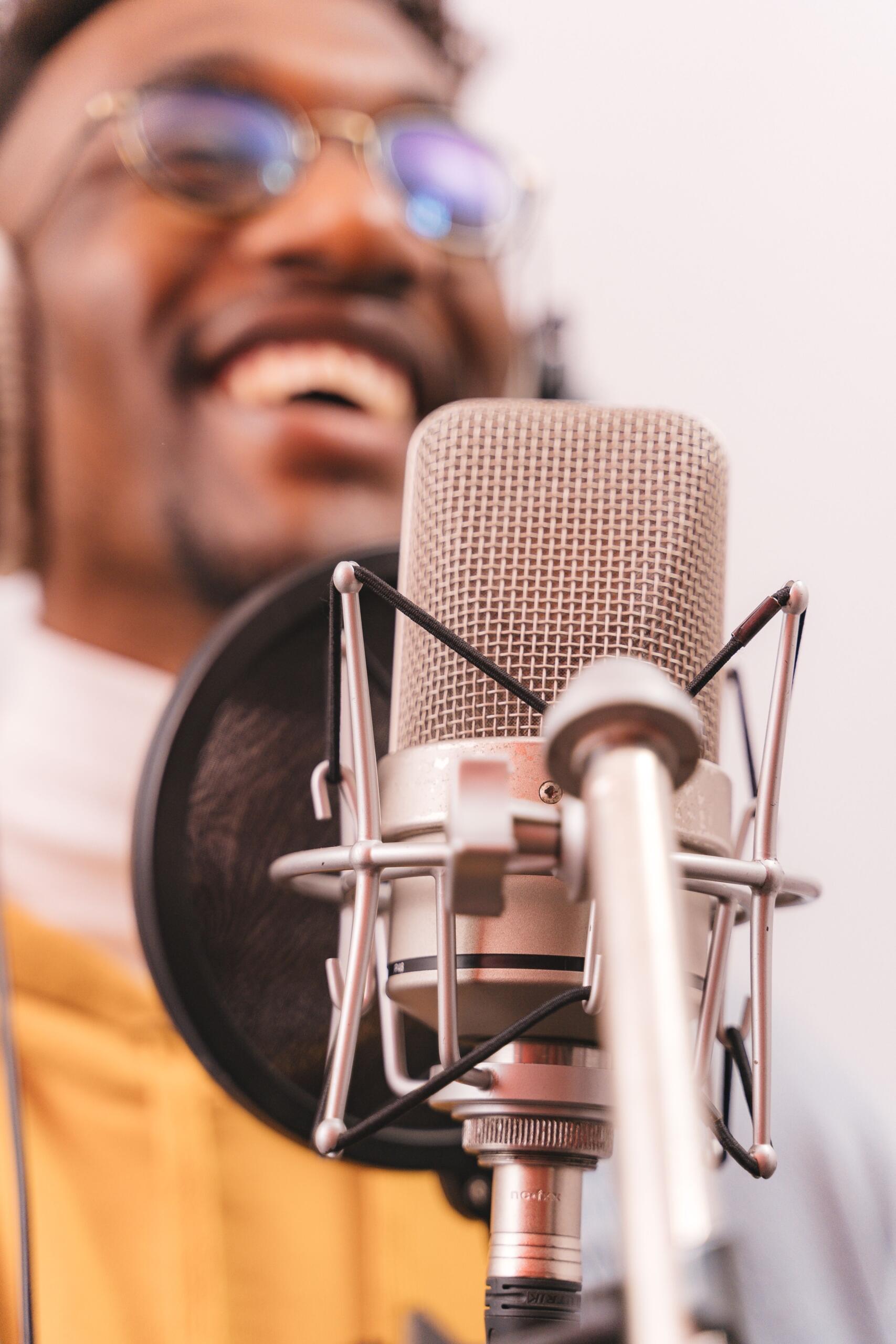 An image of a singer in the background and microphone in the foreground.