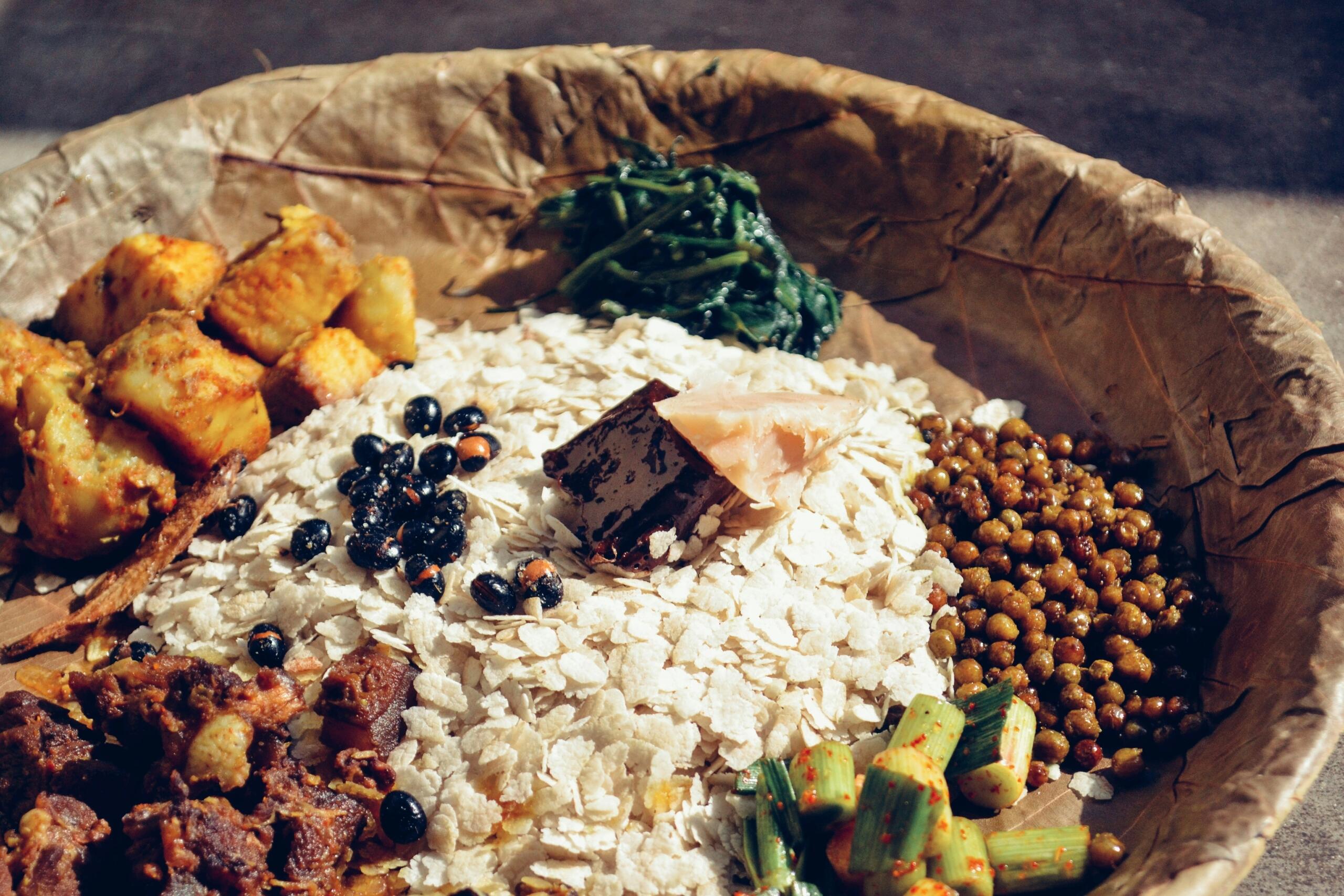 A traditional plate filled with different food including spinach, beans, and rice