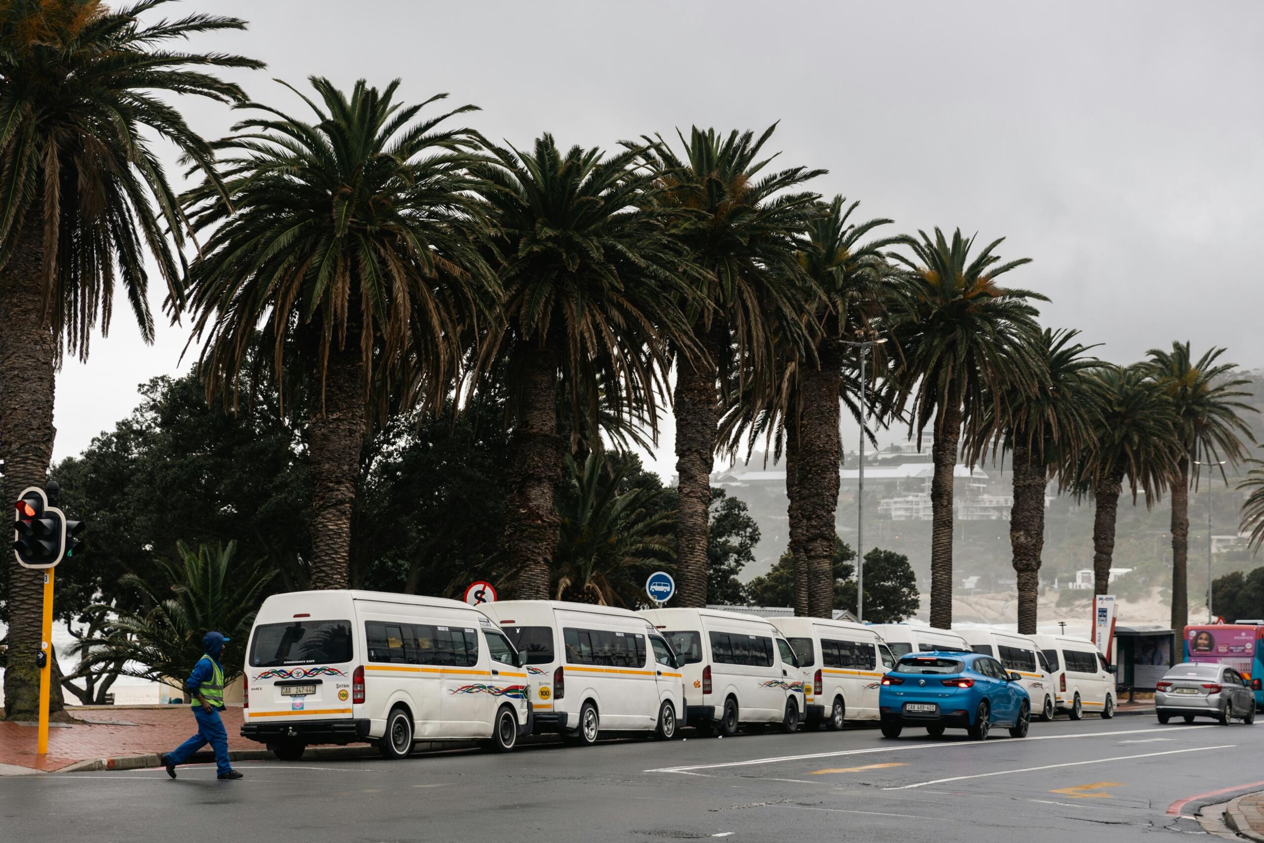 Traffic and minibus taxis parked on a road in Camps Bay, Cape Town.