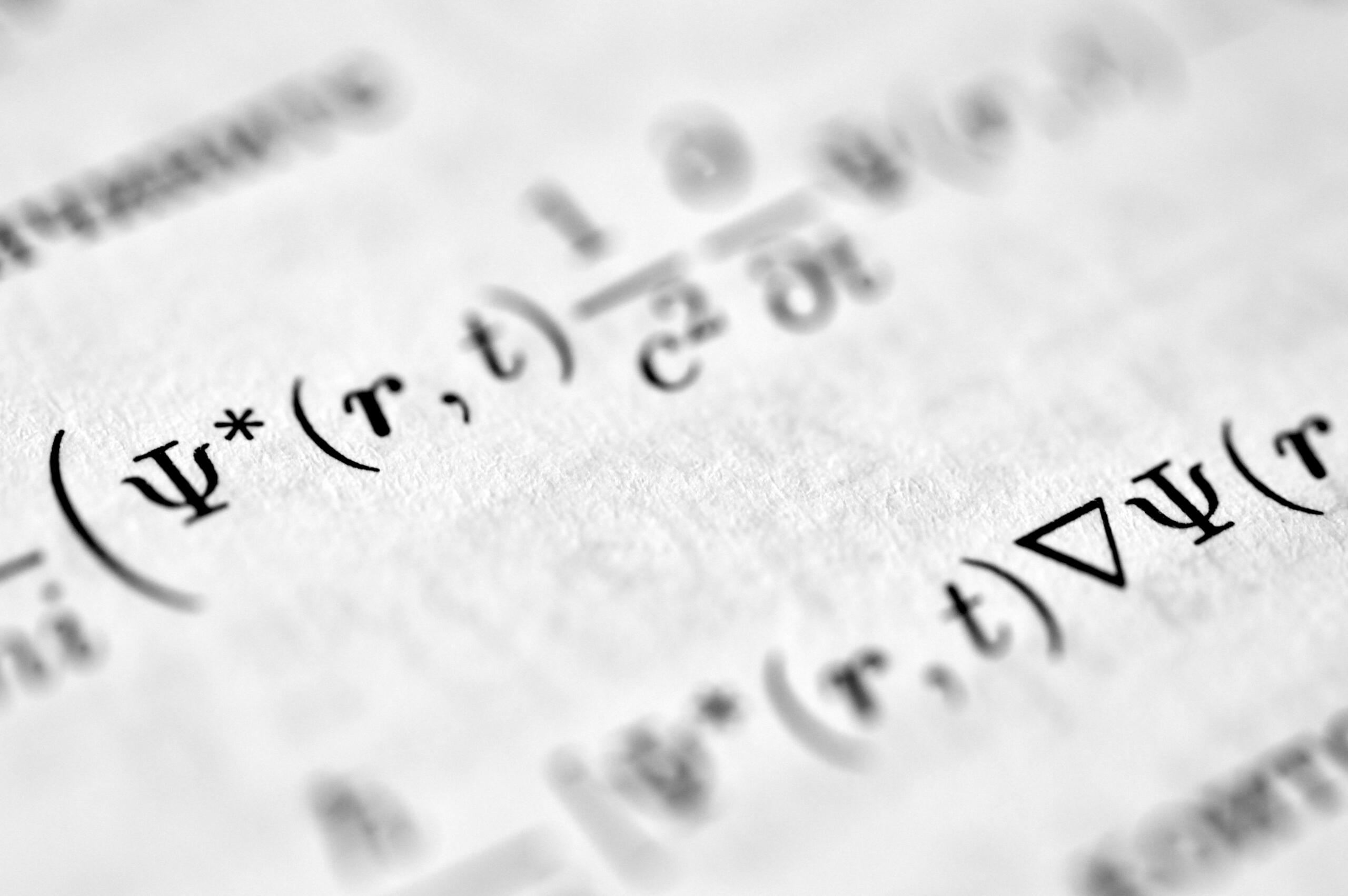 Close up of mathematical equations and formulas on a page.