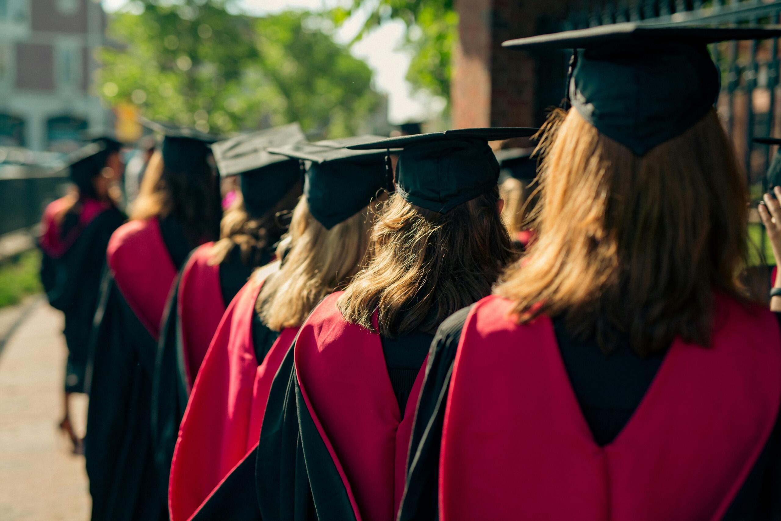 An image of graduates wearing caps and gowns at a university graduation ceremony.