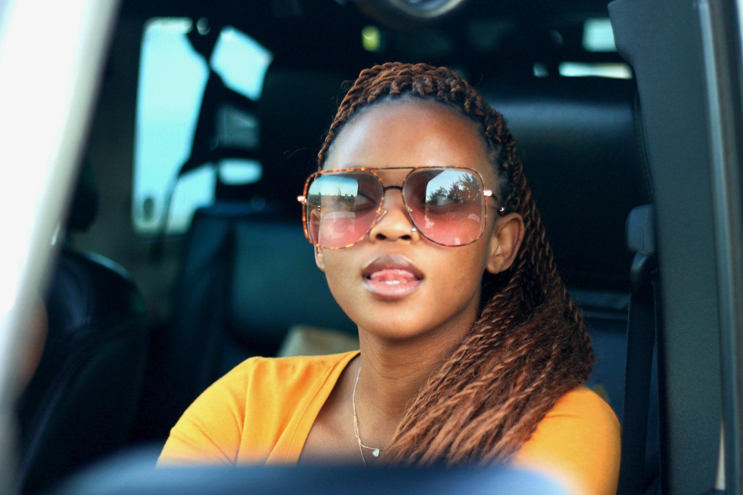 A young trendy woman sitting in a car.