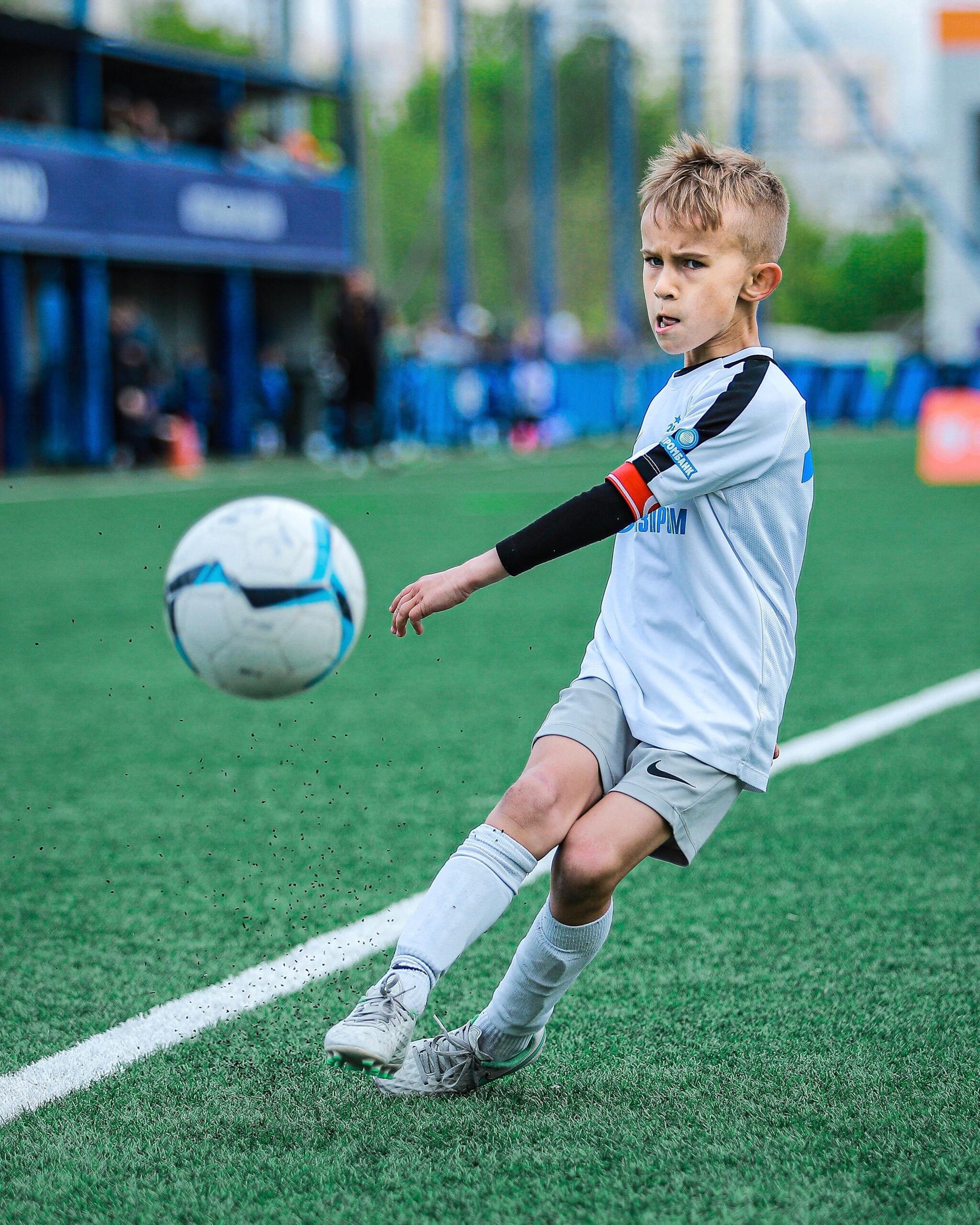 A young soccer player kicks the ball with confidence.
