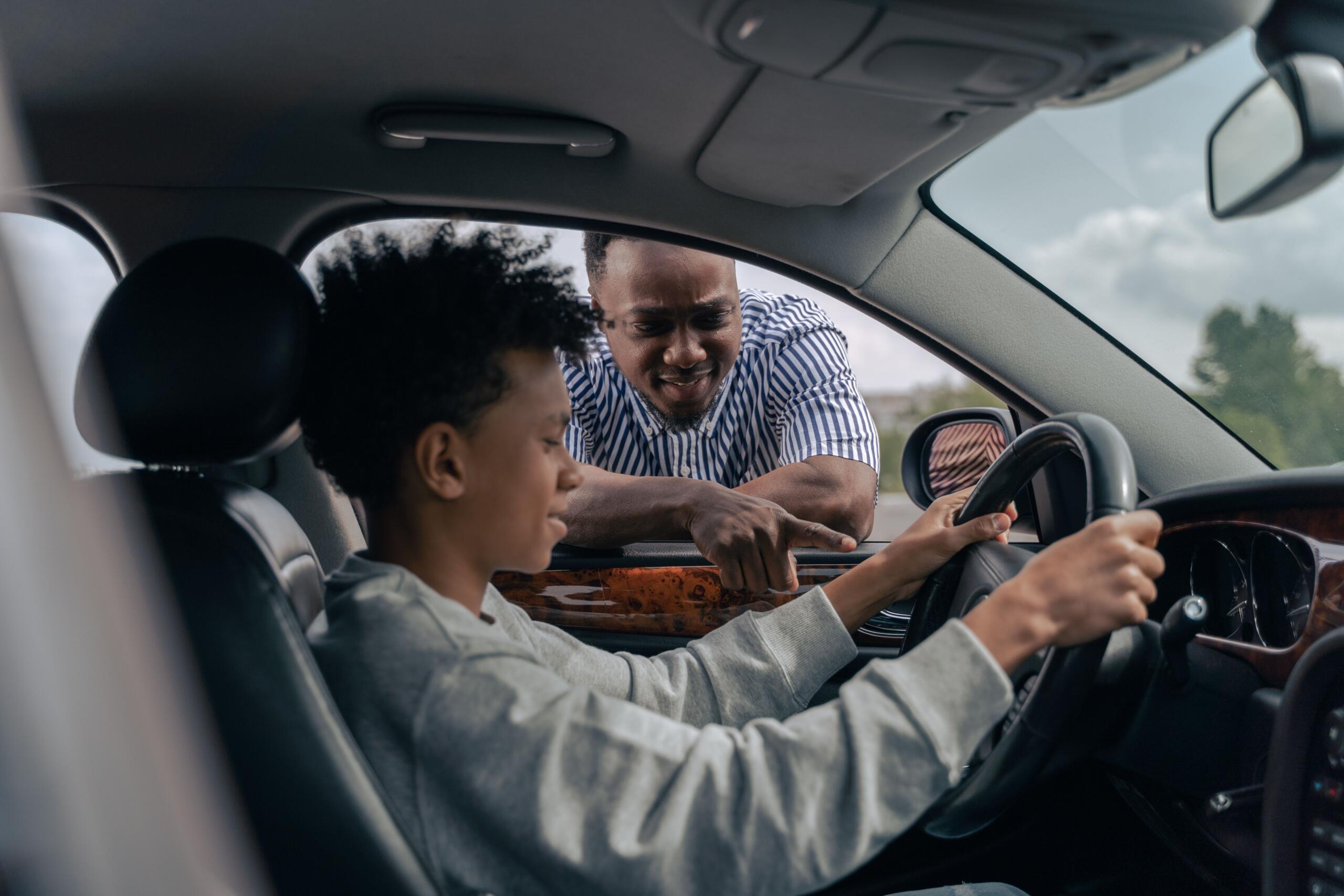 An image of a learner driver practising behind the wheel with an instructor.