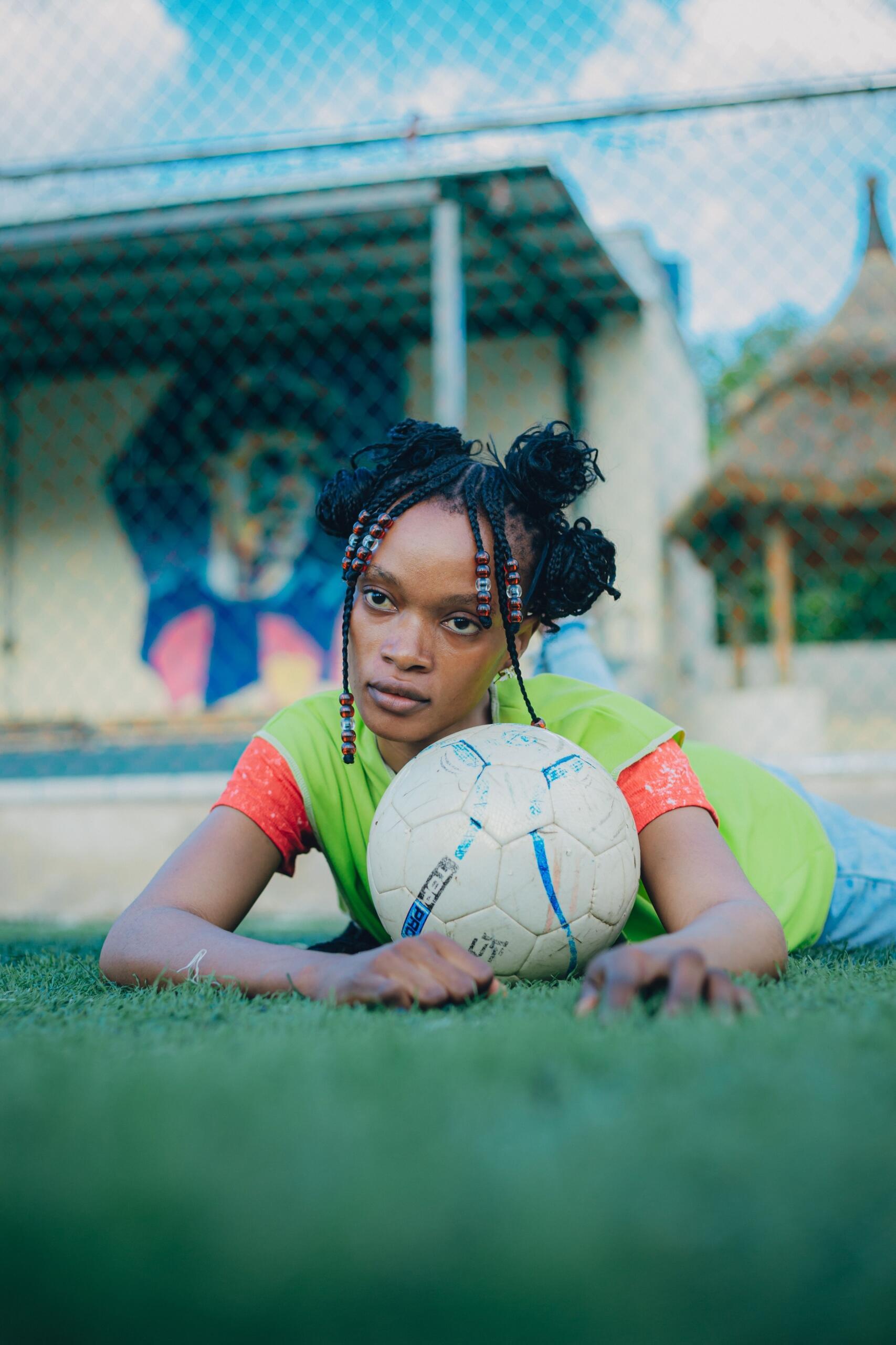 Young girl footballer holding a ball during a training session.