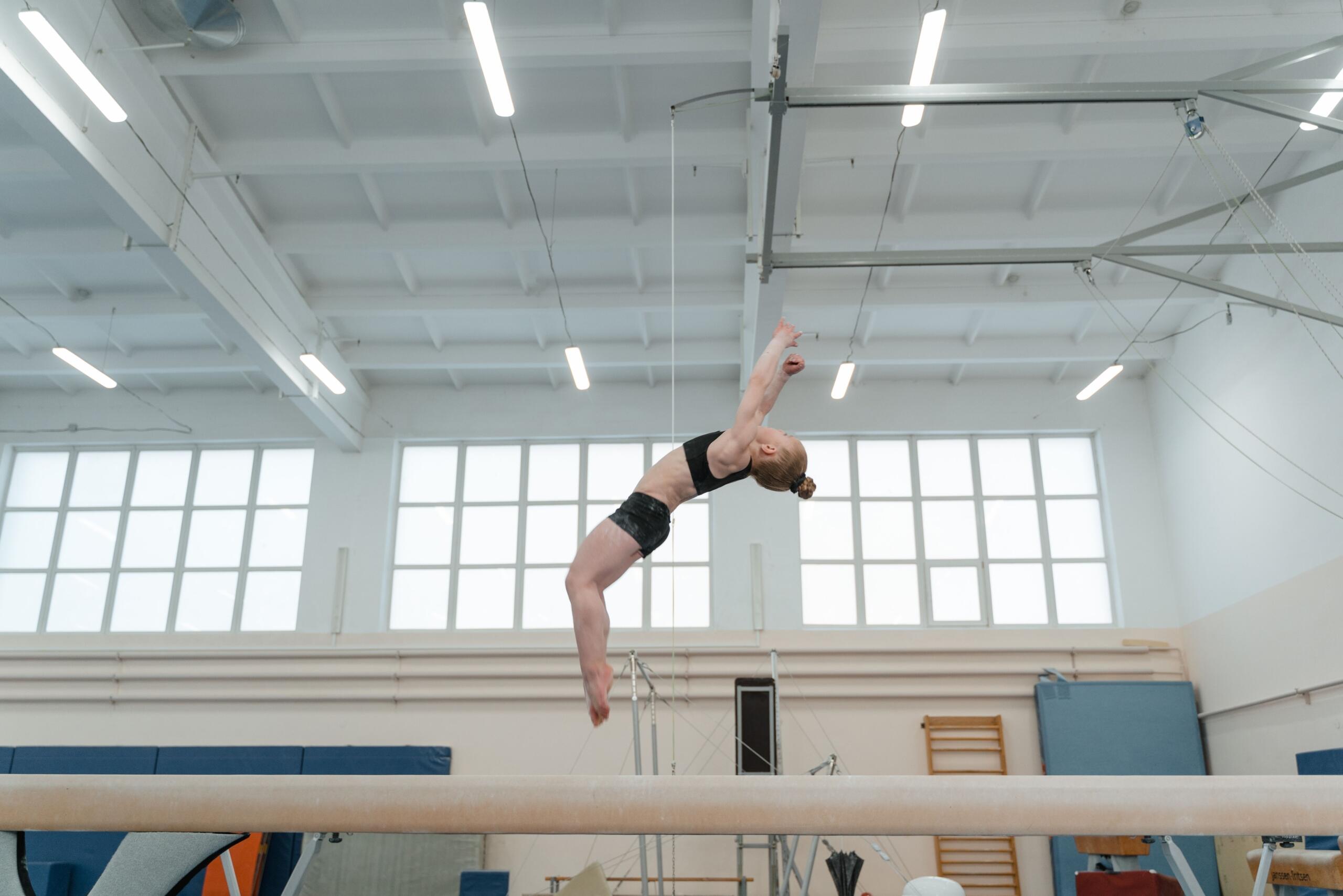 a-girl-doing-a-backflip-on-a-balance-beam