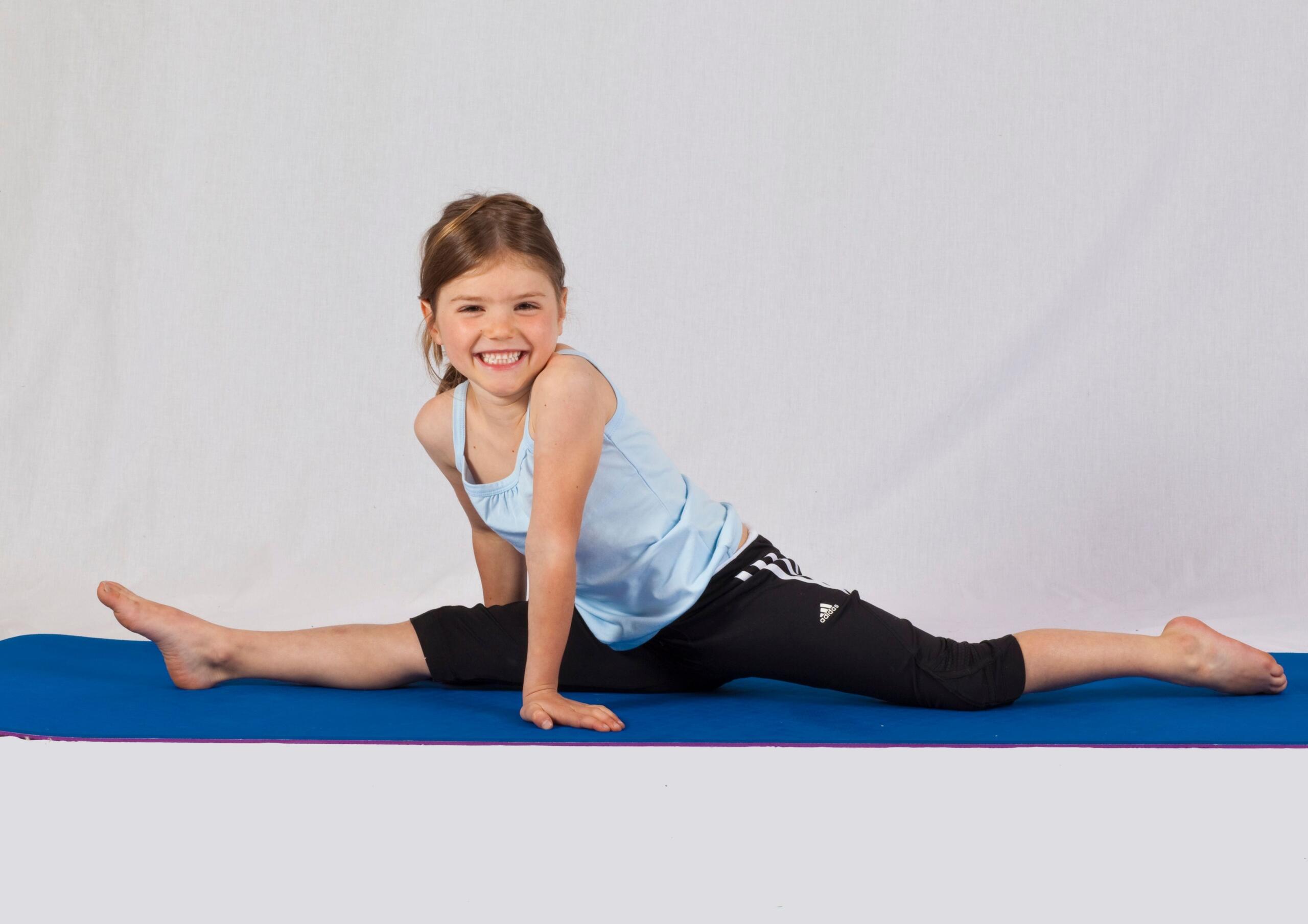 girl doing the splits on a training mat