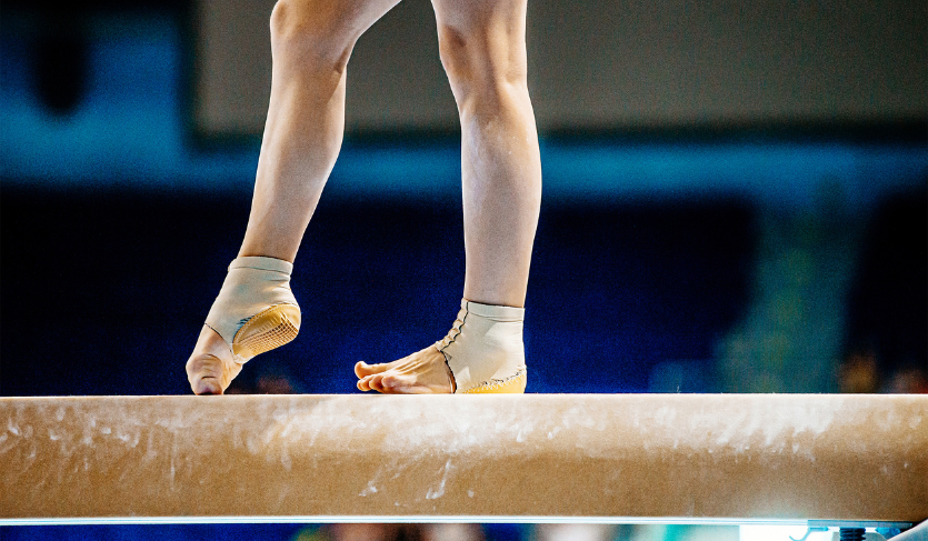 Close-up of the feet of a gymnast walking on a balance beam